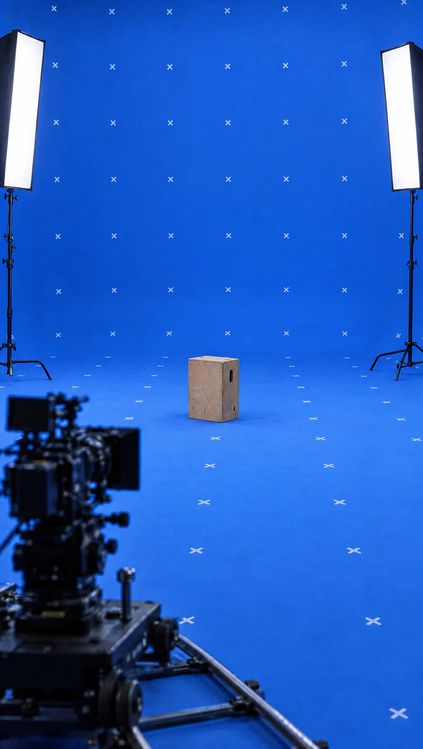 A blue-screen stage: chroma-key cyc with tracking crosses, two soft lights and a film camera. Retro Studios reference still, Blue Screen direction.